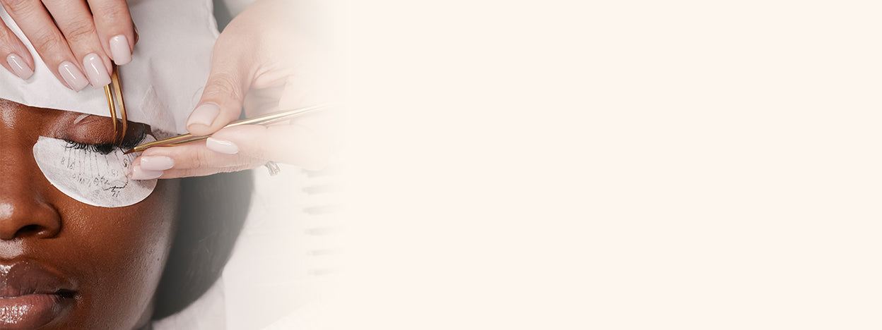 Eyelash tweezers applying eyelash extensions to natural lashes