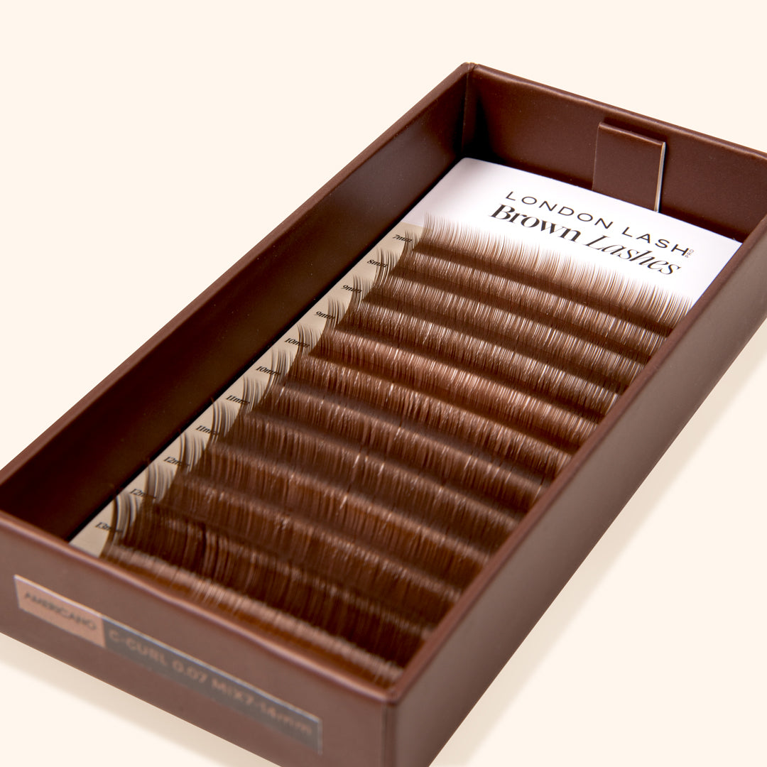 brown open lash tray with medium brown eyelashes on beige background