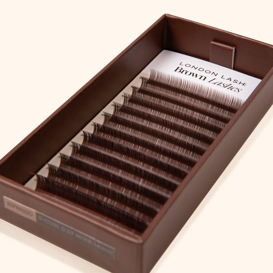 coffee shade brown eyelashes inside a carton lash tray on the beige background