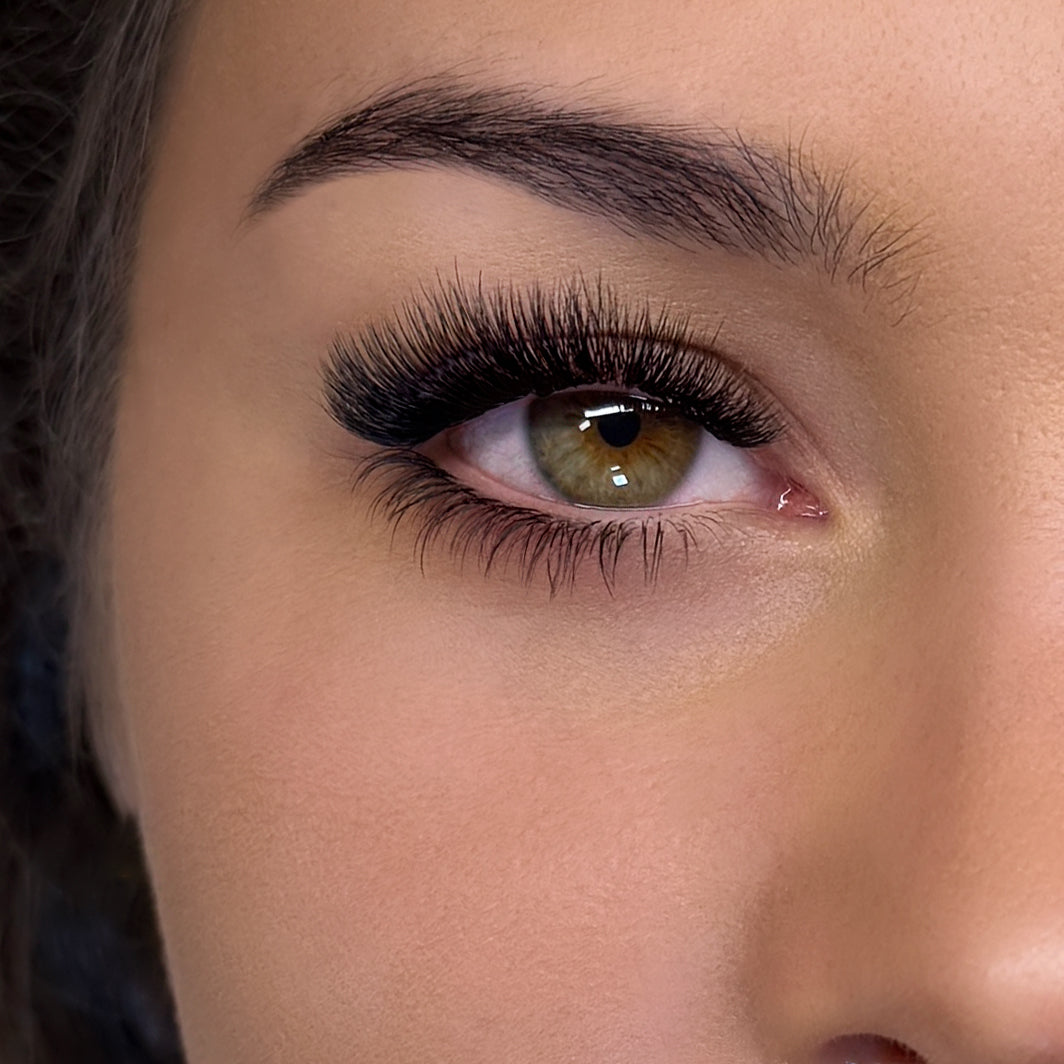 Half face of a model showing example of bottom eye lash extensions on her eye
